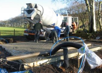 Cement mixer and men laying cement