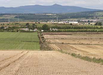 Photograph of arable fields against backdrop of hills