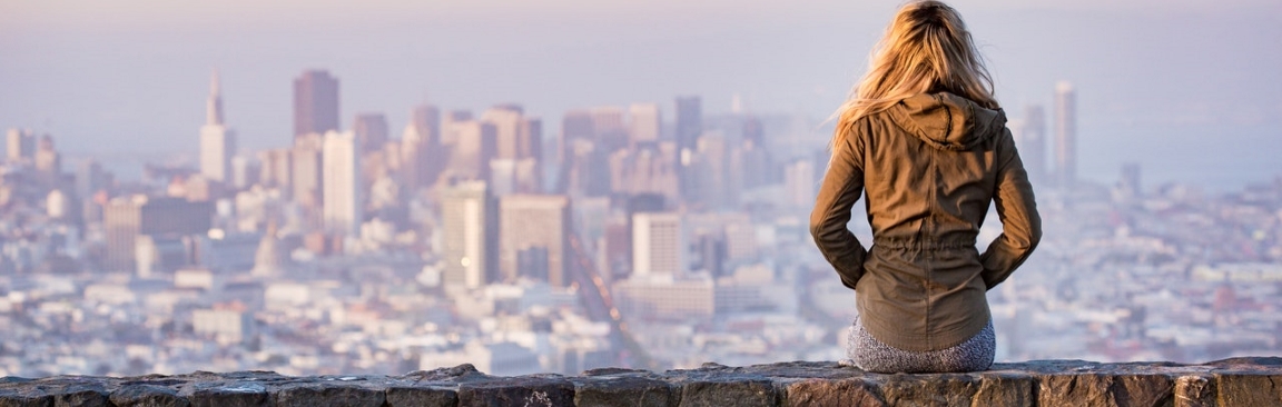 A picture of a woman looking at an urban landscape