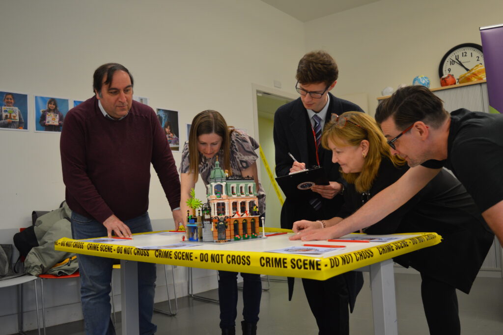 (L to R) Dr Georgios Zouganelis, Dr Katherine Brown, Andrew Jenkins, Dr Lorna Dawson and Dr Nick Dawnay investigating a Lego crime scene. 