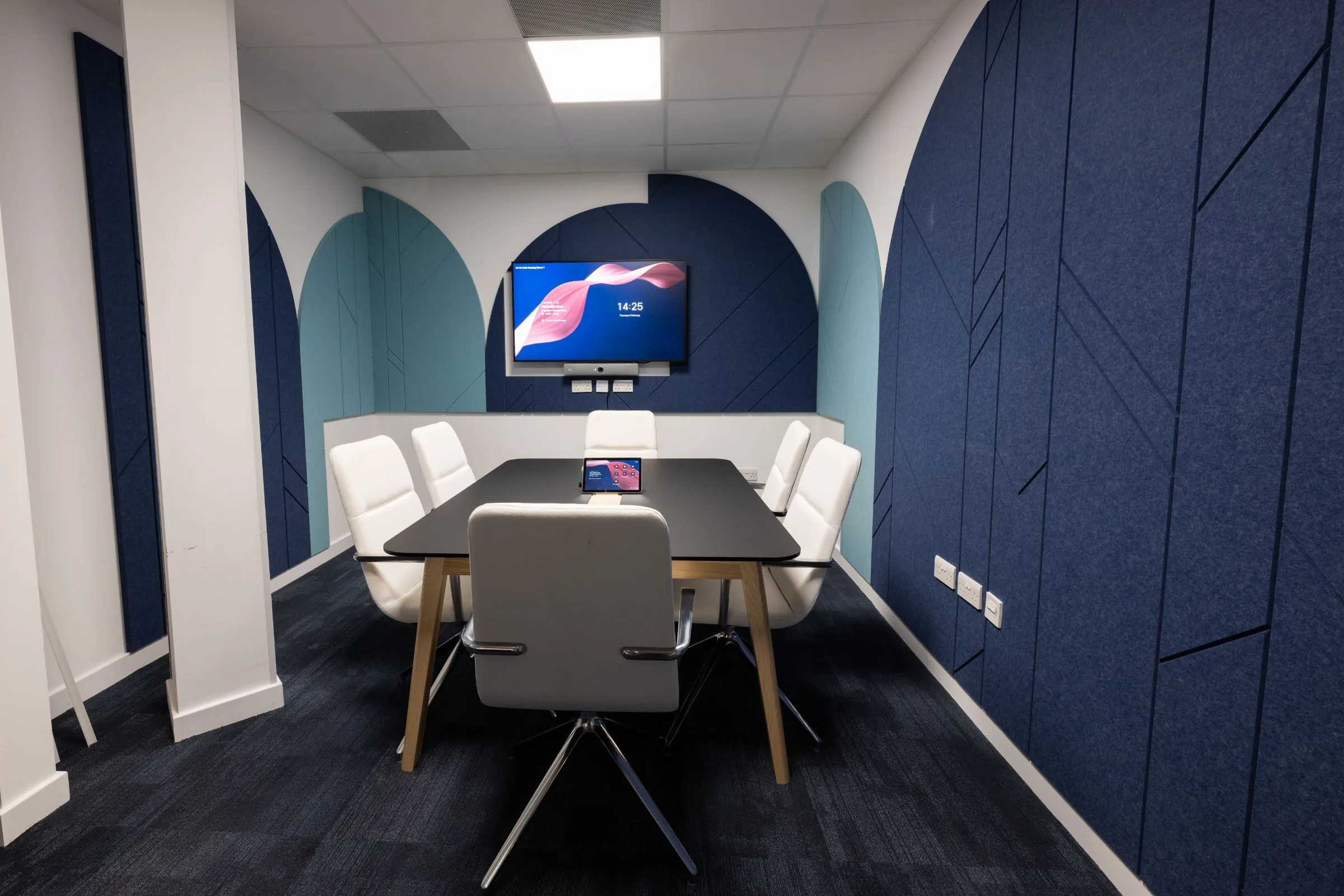 Caf&eacute; meeting room at the Hutton Hub with a six-seat table, video conferencing screen and acoustic wall panels